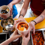 hands holding cup with food