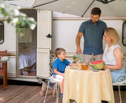 family taking the lunch next to a caravan