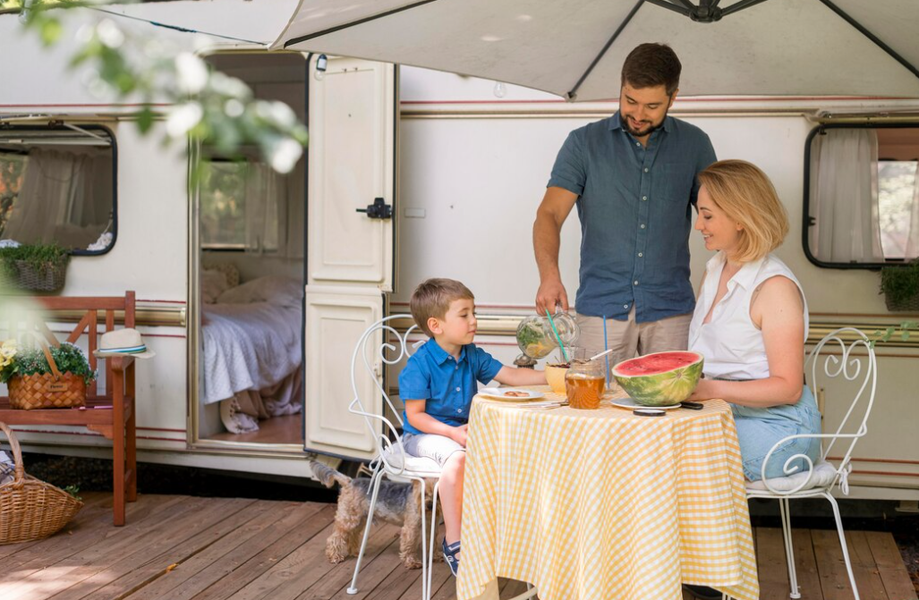 family taking the lunch next to a caravan